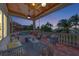 A covered outdoor living space features ample seating, stylish decor, and a view of the pool at dusk at 17509 Ohara Dr, Port Charlotte, FL 33948