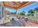 A covered outdoor living space features ample seating, stylish decor, and a view of the pool and lush landscape at 17509 Ohara Dr, Port Charlotte, FL 33948