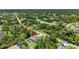 This is an aerial view of a home with screened pool, embraced by verdant trees, in a tranquil neighborhood setting at 1762 Mincey Ter, North Port, FL 34286