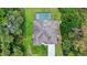Aerial view of a property with a screened-in pool surrounded by lush greenery and a long driveway at 1762 Mincey Ter, North Port, FL 34286