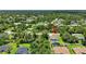 This is an aerial shot features a charming home with a screened pool, surrounded by lush greenery in a serene neighborhood setting at 1762 Mincey Ter, North Port, FL 34286