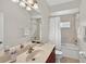 Bright bathroom featuring a marble countertop, decorative mirror and a shower and bathtub combo at 1762 Mincey Ter, North Port, FL 34286