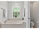 Bright bathroom featuring a soaking tub with a window, alongside a separate toilet room for added privacy at 1762 Mincey Ter, North Port, FL 34286