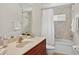 Bright bathroom featuring a marble countertop, decorative mirror and a shower and bathtub combo at 1762 Mincey Ter, North Port, FL 34286