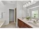 Bathroom featuring double sink vanity, a large mirror, and an open doorway to the shower at 1762 Mincey Ter, North Port, FL 34286
