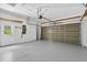 Spacious garage with painted floors, a side entrance, and an automatic garage door at 1762 Mincey Ter, North Port, FL 34286