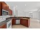 A kitchen features stainless steel appliances and tile flooring with a partial view of the living area at 1762 Mincey Ter, North Port, FL 34286