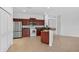Well-lit kitchen with dark wood cabinets, stainless steel appliances, and bar seating at 1762 Mincey Ter, North Port, FL 34286