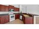 Functional kitchen with wood cabinets, stainless steel appliances, and tile floors at 1762 Mincey Ter, North Port, FL 34286