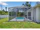 This is an inviting screened-in backyard pool offering a private retreat surrounded by lush green landscaping and clear blue skies at 1762 Mincey Ter, North Port, FL 34286