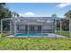 This is a backyard featuring a screened-in pool, merging relaxation with privacy in a lush, well-maintained setting under the sky at 1762 Mincey Ter, North Port, FL 34286