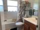 Well-lit bathroom with a tub, a decorative shower curtain, and a vanity with a wood-finish cabinet at 18094 Ackerman Ave, Port Charlotte, FL 33948