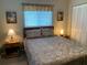 Bright bedroom with a bed, two nightstands, and tropical-themed artwork, creating a peaceful retreat at 18094 Ackerman Ave, Port Charlotte, FL 33948