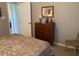 Cozy bedroom featuring a wooden dresser with a decorative mirror and a partially visible patterned bedspread at 18094 Ackerman Ave, Port Charlotte, FL 33948