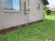 The exterior is shown with mulch along the foundation, green grass, and a utility connection at 18094 Ackerman Ave, Port Charlotte, FL 33948