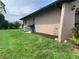 Exterior view showing the side of the home, green grass, and landscape bed with mulch at 18094 Ackerman Ave, Port Charlotte, FL 33948