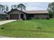 Charming single-story home featuring an attached garage and well-maintained lawn at 18094 Ackerman Ave, Port Charlotte, FL 33948