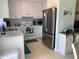 Bright kitchen with white cabinets, modern stainless steel appliances, and tile flooring at 18094 Ackerman Ave, Port Charlotte, FL 33948