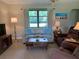 Bright living room featuring a comfortable sofa, large window, and charming decor at 18094 Ackerman Ave, Port Charlotte, FL 33948