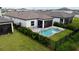 Aerial view of private backyard featuring a pool, screened-in patio, and black metal fence at 1992 Sunset Preserve Way, Port Charlotte, FL 33953