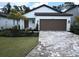 Charming single-story home with a well-manicured lawn, brick driveway, and attached two-car garage at 1992 Sunset Preserve Way, Port Charlotte, FL 33953
