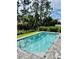 Secluded backyard pool with brick pavers and a black metal fence with lush foliage at 1992 Sunset Preserve Way, Port Charlotte, FL 33953