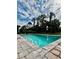 Beautiful backyard pool surrounded by brick pavers and lush trees at 1992 Sunset Preserve Way, Port Charlotte, FL 33953