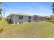 Spacious backyard featuring lush green grass, a screened-in pool, and mature landscaping for a private outdoor retreat at 2141 Rio De Janeiro Ave, Punta Gorda, FL 33983