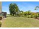 Expansive backyard with lush green lawn and mature trees, offering privacy and shade at 2141 Rio De Janeiro Ave, Punta Gorda, FL 33983