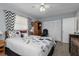 Comfortable bedroom with wood-look floors, ceiling fan, and black and white floral-patterned bedding and curtains at 2141 Rio De Janeiro Ave, Punta Gorda, FL 33983