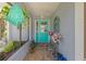 Charming front entryway with teal door, decorative plants, and a brick floor at 2141 Rio De Janeiro Ave, Punta Gorda, FL 33983