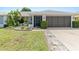 Charming single-story home featuring a well-manicured lawn, inviting entrance, and an attached two-car garage at 2141 Rio De Janeiro Ave, Punta Gorda, FL 33983