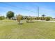 Exterior view of a home with large front yard, mature trees, and well-kept landscaping at 2141 Rio De Janeiro Ave, Punta Gorda, FL 33983