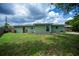 Spacious backyard with a well-maintained lawn and a small patio area perfect for outdoor relaxation at 21539 Gladis Ave, Port Charlotte, FL 33952