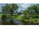 Waterfront home backyard with mature trees and lush landscaping at 21539 Gladis Ave, Port Charlotte, FL 33952