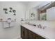 Bathroom featuring double sink vanity with white countertop, decor palm trees, and stone accent wall at 21539 Gladis Ave, Port Charlotte, FL 33952