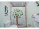 Bathroom with a palm tree shower curtain, decorative parrot art and a white toilet at 21539 Gladis Ave, Port Charlotte, FL 33952