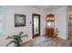 Welcoming entryway featuring wood-look floors, a decorative shelf, and a stylish front door with glass accents at 21539 Gladis Ave, Port Charlotte, FL 33952