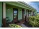 Inviting front porch featuring decorative columns, a glass front door, and manicured landscaping for curb appeal at 21539 Gladis Ave, Port Charlotte, FL 33952