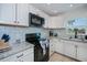Clean kitchen with updated appliances, white cabinets, and granite counters at 21539 Gladis Ave, Port Charlotte, FL 33952