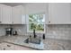 Bright kitchen with granite countertops, tile backsplash, and a view to the yard at 21539 Gladis Ave, Port Charlotte, FL 33952