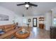 Bright living room with a ceiling fan, a large front window, and a comfortable seating area at 21539 Gladis Ave, Port Charlotte, FL 33952