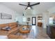 Bright living room featuring a comfortable sectional sofa, ceiling fans, and wood-look floors perfect for relaxation at 21539 Gladis Ave, Port Charlotte, FL 33952