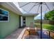 Covered patio area with glass top table and access to the laundry machines at 21539 Gladis Ave, Port Charlotte, FL 33952