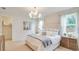 This primary bedroom features a large window, chandelier, and carpeted floors at 2308 Oberon Ln, Punta Gorda, FL 33983