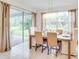 Dining room with large windows and sliding glass doors and neutral-toned furnishings at 2308 Oberon Ln, Punta Gorda, FL 33983