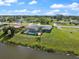 An aerial view of a grey house with a screened pool area and a view of a nearby lake at 2309 Conway Blvd, Port Charlotte, FL 33952