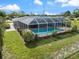 Aerial view of a home with a screened-in pool and lush landscaping at 2309 Conway Blvd, Port Charlotte, FL 33952