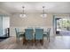 Dining area with wood-look flooring, slider to outdoor patio, and modern chandelier at 2309 Conway Blvd, Port Charlotte, FL 33952
