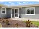 Charming exterior showcasing a gray facade, an inviting front entry, and well-maintained landscaping at 2309 Conway Blvd, Port Charlotte, FL 33952